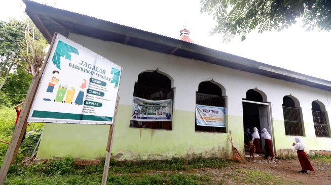 Sejumlah siswa SD Negeri 1 berjalan ke dalam masjid yang dijadikan sekolah di Bone Raya, Kabupaten Bone Bolango, Gorontalo, Kamis (18/9/2025).  [ANTARA FOTO/Adiwinata Solihin/YU]