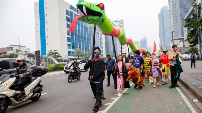 Aktivis dari berbagai organisasi melakukan aksi Draw the Line dengan cara long march dari terowongan Kendal menuju Monas, Jakarta, Jumat (19/9/2025). [Suara.com/Alfian Winanto]
