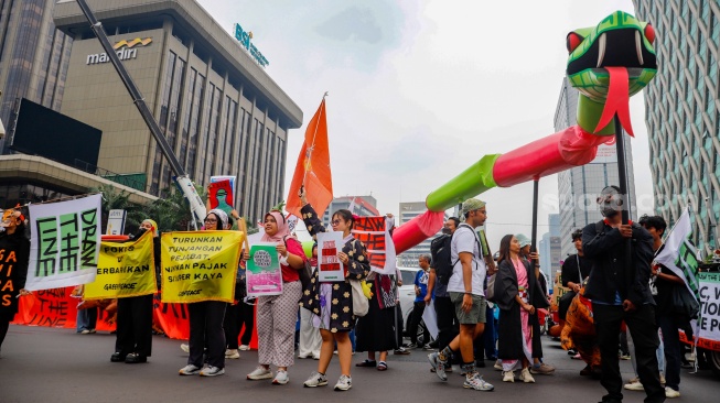 Aktivis dari berbagai organisasi melakukan aksi Draw the Line dengan cara long march dari terowongan Kendal menuju Monas, Jakarta, Jumat (19/9/2025). [Suara.com/Alfian Winanto]