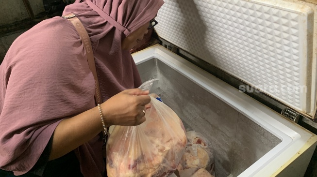 Nani Sukowati memeriksa persediaan daging di tempat usaha gilingan yang di kawasan Banguntapan, Bantul, Kamis (18/9/2025). (Suara.com/Irwan Febri Rialdi)