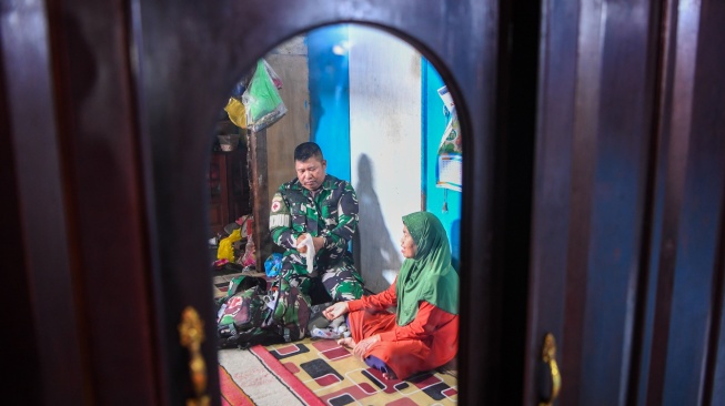Prajurit TNI AD anggota Kodim 0906/Kutai Kartanegara, Peltu Suhendro bersiap memeriksa kesehatan warga saat melakukan pelayanan klinik terapung di kawasan Loa Ipuh, Tenggarong, Kutai Kartanegara, Kalimantan Timur, Jumat (19/9/2025). [ANTARA FOTO/M Risyal Hidayat/tom]