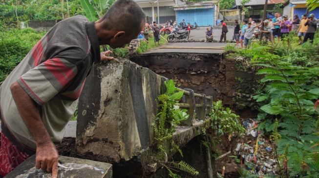 Warga melihat kondisi jembatan yang putus di Desa Kandangtepus, Kecamatan Senduro, Lumajang, Jawa Timur, Jumat (19/9/2025).  [ANTARA FOTO/Irfan Sumanjaya/tom]