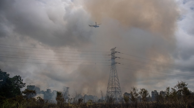 Helikopter MI-8Mtv milik Badan Nasional Penanggulangan Bencana (BNPB) melakukan pemadaman kebakaran lahan dari udara (water boombing) yang terjadi di sisi gerbang tol rambutan Jalan Tol Trans Sumatera (JTTS) ruas Palembang-Indralaya (Palindra) di Desa Rambutan, Ogan Ilir (OI), Sumatera Selatan, Minggu (21/9/2025). [ANTARA FOTO/Nova Wahyudi/bar]