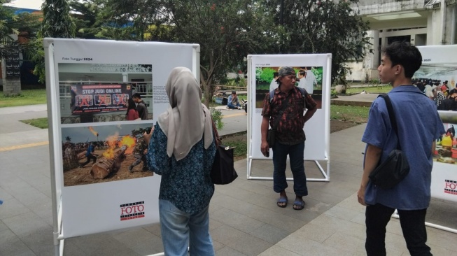 Pengunjung Saat Melihat Foto-foto di Pameran Foto PFI Bogor 'Satu Dekade PFI Bogor' di Alun-alun Kota Bogor [Andi/Suarabogor].