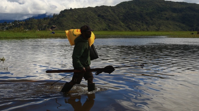 Seorang warga melintas di sekitar pinggiran Danau Paniai di Kampung Kogekotu, Kecamatan Paniai Timuri, Kabupaten Paniai, Provinsi Papua Tengah, Rabu (24/9/2025). [ANTARA FOTO/Gusti Tanati/nz]