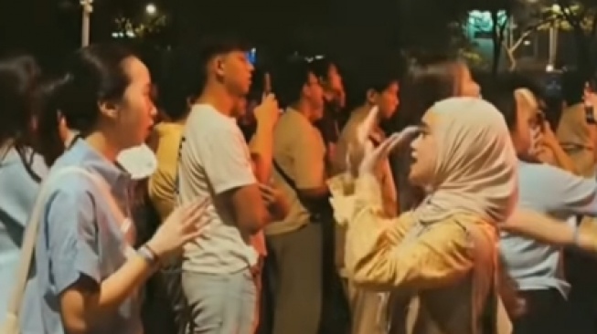 Seorang perempuan berhijab jadi sorotan saat berusaha menerjemahkan sebuah lagu ke  bahasa isyarat dalam sebuah konser  (Instagram)
