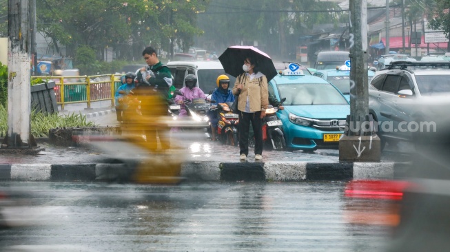 Pejalan kaki menggunakan payung saat hujan di Kawasan Slipi, Jakarta, Senin (29/9/2025). [Suara.com/Alfian Winanto]