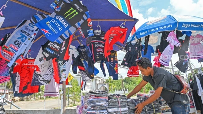 Pedagang menata kaos serta pernak-pernik bertema MotoGP di depan Sirkuit Mandalika, KEK Mandalika, Kuta, Praya, Lombok Tengah, NTB, Senin (29/9/2025). [ANTARA FOTO/Ahmad Subaidi/bar]
