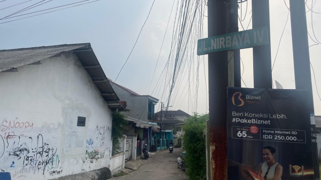 Plang Jalan Nirbaya yang berada di Kawasan Pinang Ranti, Jakarta Timur. Sejumlah literatur menyebut di kawasan ini pernah berdiri bangunan Inrehab Nirbaya yang menjadi tempat tahanan Tapol Orde Baru. [Suara.com/Yaumal]