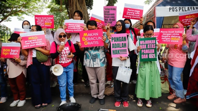 Massa yang tergabung dalam Suara Ibu Peduli Makan Bergizi Gratis (MBG) melakukan aksi di trotoar sekitar IRTI Monas, Jakarta, Rabu (1/10/2025). [Suara.com/Alfian Winanto]