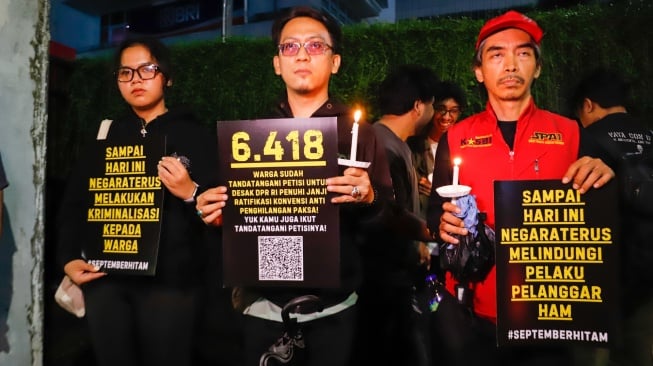 Massa yang tergabung dalam Koalisi Masyarakat Sipil menggelar aksi peringatan satu bulan korban tragedi aksi Agustus di kawasan Bendungan Hilir, Jakarta, Selasa (30/9/2025) malam. [Suara.com/Alfian Winanto]