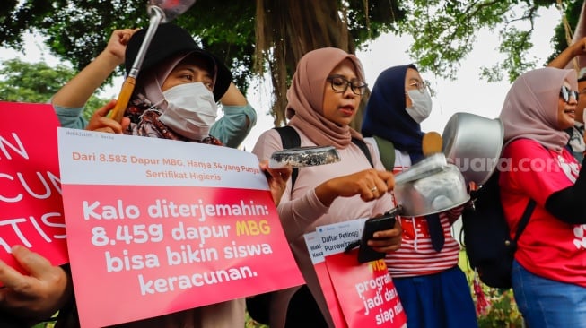 Massa yang tergabung dalam Suara Ibu Peduli Makan Bergizi Gratis (MBG) melakukan aksi di trotoar sekitar IRTI Monas, Jakarta, Rabu (1/10/2025). [Suara.com/Alfian Winanto]