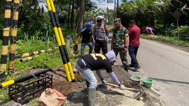 Sejumlah pekerja memasang rambu untuk aturan melintas truk tambang di wilayah Sedogan-Balerante, Sleman, Kamis (2/10/2025). (dok.Istimewa)
