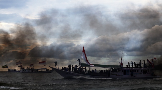 Sejumlah warga berada di atas kapal nelayan berhias bendera berkeliling saat mengikuti pesta nelayan di kawasan Pantai Kasiwa, Mamuju, Sulawesi Barat, minggu (5/10/2025). [ANTARA FOTO/Akbar Tado/foc]
