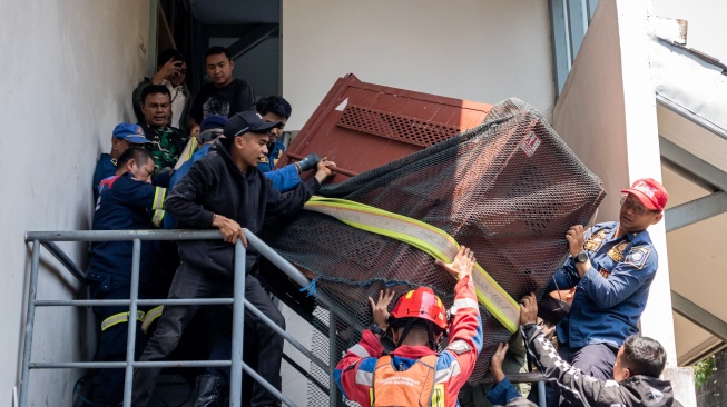 Tim gabungan mengangkat kandang yang berisi seekor macan tutul (Panthera pardus) untuk dievakuasi di Anugerah Hotel, Bandung, Jawa Barat, Senin (6/10/2025). [ANTARA FOTO/Abdan Syakura/tom]
