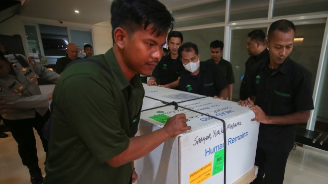 Petugas kargo jenazah menurunkan peti jenazah Alm Yurike Marianne Sanger setibanya dari Kota New York , Amerika Serikat di Terminal kargo Bandara Soekarno Hatta, Tangerang, Banten, Minggu (5/10/2025). [ANTARA FOTO/Muhammad Iqbal/foc]