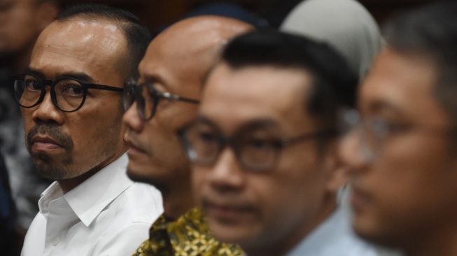 Terdakwa kasus dugaan korupsi tata kelola minyak mentah dan produk kilang pada PT Pertamina Riva Siahaan (kiri), Sani Dinar Saifuddin (kedua kiri), Maya Kusmaya (kedua kanan), dan Edward Corne (kanan) menunggu dimulainya sidang dakwaan di Pengadilan Tipikor, Jakarta, Kamis (9/10/2025). [ANTARA FOTO/Indrianto Eko Suwarso/nym]
