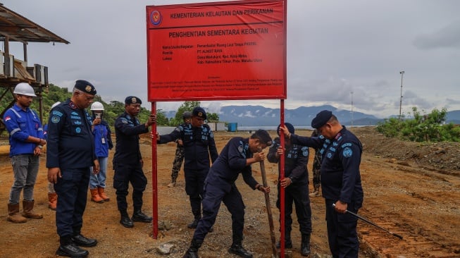 Sejumlah personel Polisi Khusus Pengelolaan Pesisir dan Pulau-pulau Kecil (Polsus PWP3K) Ditjen PSDKP memasang papan penyegelan di kawasan PT. Alngit Raya di Desa Wailukum, Kecamatan Kota Maba, Kabupaten Halmahera Timur, Maluku Utara, Kamis (9/10/2025).  [ANTARA FOTO/Andri Saputra/nym]