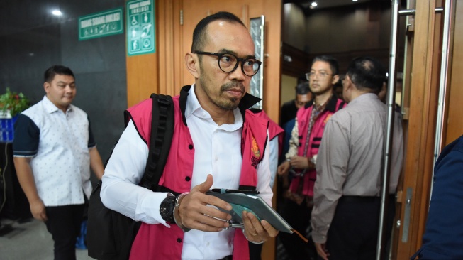 Terdakwa kasus dugaan korupsi tata kelola minyak mentah dan produk kilang pada PT Pertamina Riva Siahaan (tengah) bersama Edward Corne (kanan) berjalan usai mengikuti sidang dakwaan di Pengadilan Tipikor, Jakarta, Kamis (9/10/2025). [ANTARA FOTO/Indrianto Eko Suwarso/nym]