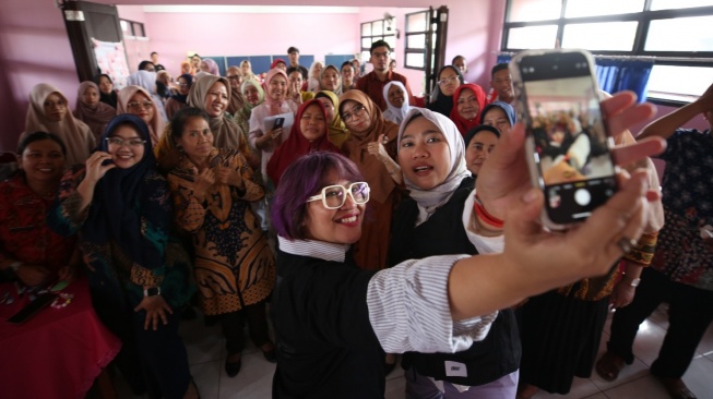 Corporate Brand Management Lead Bank Jago Deviana (kiri) dan Certified Financial Planner & Sustainability Specialist Bank Jago Andhina Aryani melakukan swafoto bersama guru SDN 07, SDN 08, dan SMPN 117 Duren Sawit seusai acara edukasi keuangan guru jago Financial di Jakarta, Kamis (9/10/2025). [Handout]