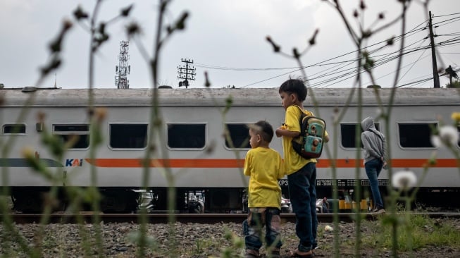 Warga menyaksikan rangkaian kereta api (KA) melintas di Stasiun Cimahi, Kota Cimahi, Jawa Barat, Sabtu (11/10/2025). [ANTARA FOTO/Abdan Syakura/rwa]