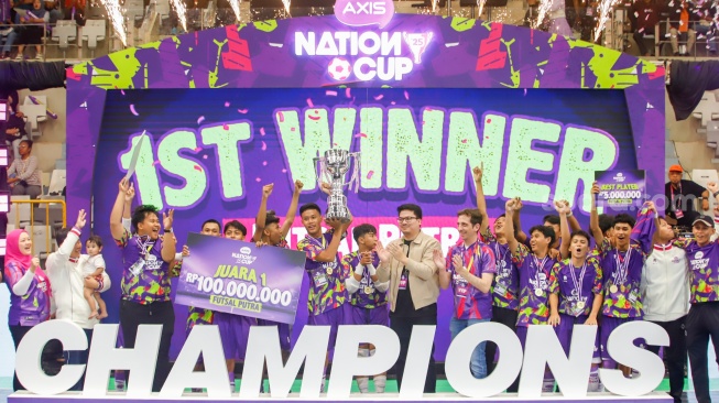 Ketua Umum Federasi Futsal Indonesia Michael Sianipar (tengah) didampingi Chief Marketing Officer XLSMART Alfons Bosch Sansa (keenam kanan) menyerahkan piala kepada tim futsal putra SMK Nusantara Jakarta Barat sebagai juara pertama AXIS Nation Cup (ANC) 2025 di Istora Senayan, Jakarta, Sabtu (11/10/2025). [Suara.com/Alfian Winanto]