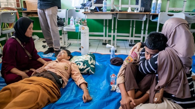 Orang tua mendampingi anaknya yang diduga keracunan hidangan makan bergizi gratis (MBG) di SMPN 1 Cisarua, Cisarua, Kabupaten Bandung Barat, Jawa Barat, Selasa (14/10/2025). [ANTARA FOTO/Abdan Syakura/nym]