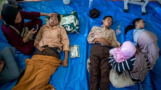 Orang tua mendampingi anaknya yang diduga keracunan hidangan makan bergizi gratis (MBG) di SMPN 1 Cisarua, Cisarua, Kabupaten Bandung Barat, Jawa Barat, Selasa (14/10/2025). [ANTARA FOTO/Abdan Syakura/nym]