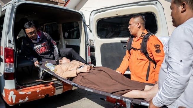 Petugas mengevakuasi siswa yang diduga keracunan hidangan makan bergizi gratis (MBG) di SMPN 1 Cisarua, Cisarua, Kabupaten Bandung Barat, Jawa Barat, Selasa (14/10/2025). [ANTARA FOTO/Abdan Syakura/nym]