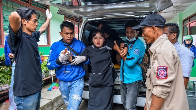 Polwan mendampingi siswa korban yang diduga keracunan hidangan Makan Bergizi Gratis (MBG) yang mendapatkan penanganan di posko penanganan keracunan MBG di SMPN 1 Cisarua, Kabupaten Bandung Barat, Jawa Barat, Rabu (15/10/2025). [ANTARA FOTO/Raisan Al Farisi/rwa]