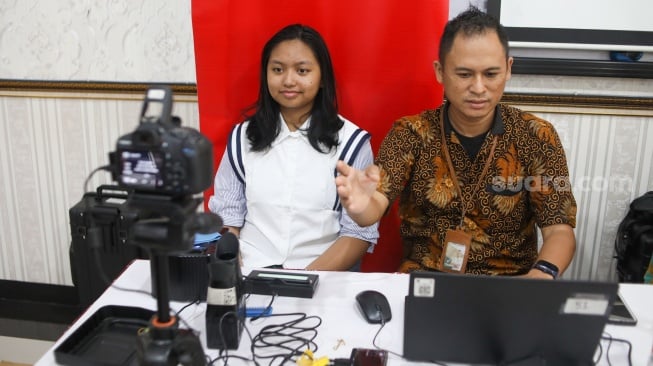 Petugas dari Dinas Kependudukan dan Pencatatan Sipil (Disdukcapil) DKI Jakarta melakukan perekaman e-KTP di SMKN 32 Jakarta, Kamis (16/10/2025). [Suara.com/Alfian Winanto]