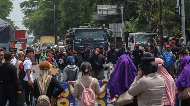 Pengunjuk rasa meminta sopir truk untuk berputar arah saat berlangsungnya aksi menuntut penertiban truk berdimensi dan bermuatan lebih atau overdimension-overload (ODOL) di Jalan Lingkar Selatan, Kota Cilegon, Banten, Kamis (16/10/2025). [ANTARA FOTO/Angga Budhiyanto/nym]