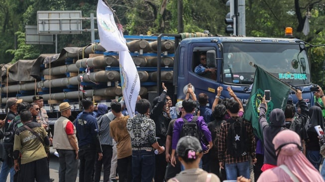 Pengunjuk rasa meminta sopir truk untuk berputar arah saat berlangsungnya aksi menuntut penertiban truk berdimensi dan bermuatan lebih atau overdimension-overload (ODOL) di Jalan Lingkar Selatan, Kota Cilegon, Banten, Kamis (16/10/2025). [ANTARA FOTO/Angga Budhiyanto/nym]