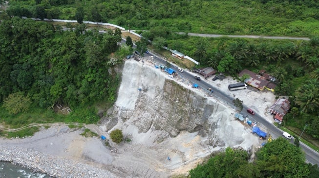 Foto udara pekerja melanjutkan pekerjaan penanganan bahu jalan longsor di Malibo Anai, Padang Pariaman, Sumatera Barat, Kamis (16/10/2025). [ANTARA FOTO/Iggoy el Fitra/nz]