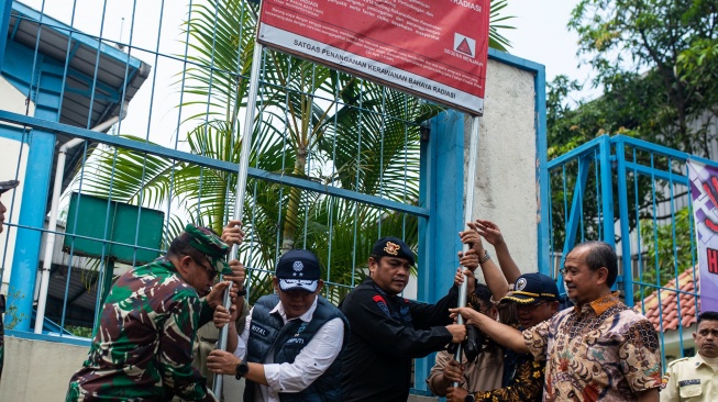 Tim gabungan Gakkum Kementerian Lingkungan Hidup bersama Polri dan TNI mencabut papan peringatan radiasi di salah satu pabrik yang telah didekontaminasi dari radiasi Cesium-137 (Cs-137) di Kawasan Industri Cikande, Kabupaten Serang, Banten, Jumat (8/10/2025). [ANTARA FOTO/Muhammad Bagus Khoirunas/foc]