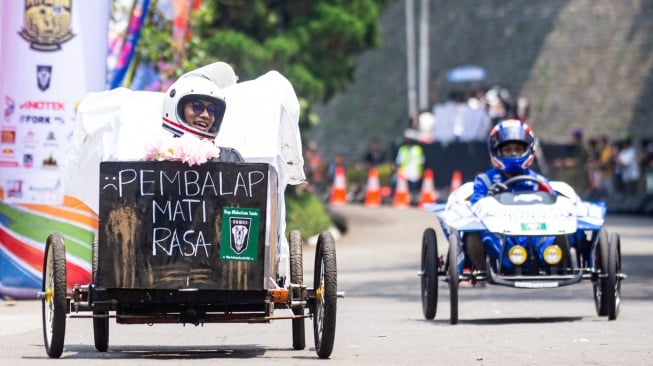 Peserta tertawa saat tiba di garis finis seusai mengikuti balapan Lomba Kereta Peti Sabun 2025 di kawasan Sasana Budaya Ganesha ITB, Bandung, Jawa Barat, Sabtu (18/10/2025). [ANTARA FOTO/Novrian Arbi/bar]
