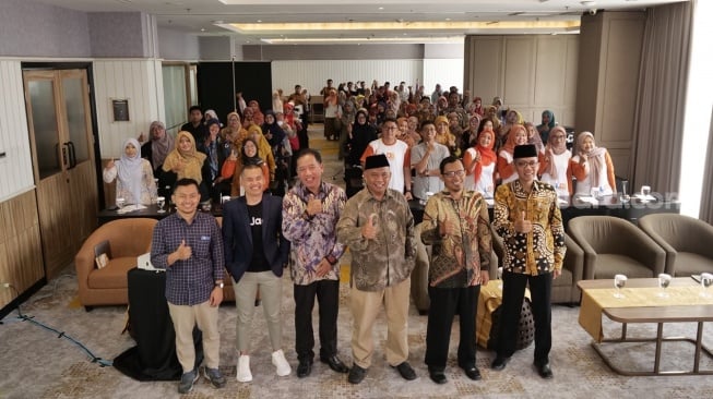 Peserta diskusi literasi bersama narasumber, tamu undangan dan CEO Suara.com, Suwarjono, berswafoto dalam kegiatan bertema Cakap Digital, Bijak Finansial: Memperkuat Hubungan Guru dan Murid di Era Teknologi, di Hotel Porta Ambarrukmo, Sleman, Sabtu (18/10/2025). [Suara.com]