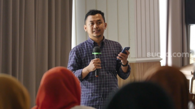 Narasumber dari Editor Bisnis Suara.com, Mohamad Nurhadi memberikan materi diskusi bertema Cakap Digital, Bijak Finansial: Memperkuat Hubungan Guru dan Murid di Era Teknologi di Hotel Porta Ambarrukmo, Sleman, Sabtu (18/10/2025). [Suara.com]