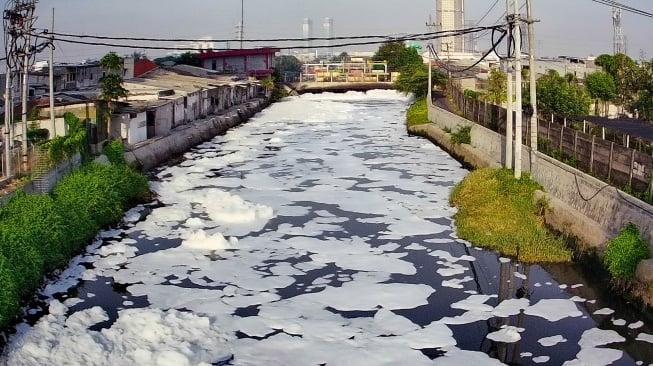 Foto udara gumpalan busa putih mengapung di permukaan sungai di Kalisari Damen, Surabaya, Jawa Timur, Senin (20/10/2025). [ANTARA FOTO/Didik Suhartono/YU]