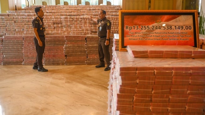 Petugas memeriksa uang tunai saat penyerahan uang pengganti kerugian negara hasil korupsi minyak kelapa sawit (CPO) di Kejaksaan Agung, Jakarta, Senin (20/10/2025). [ANTARA FOTO/Hafidz Mubarak A/YU] 