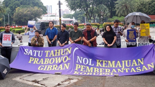 Massa dari Koalisi Bersihkan Indonesia (KBI) saat menggelar aksi simbolik di Taman Pandang Istana, Jakarta, Senin (20/10/2025). [Suara.com/Alfian Winanto]