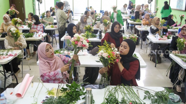 Peserta mengikuti bimbingan merangkai bunga atau hand bouquet di rangkaian Festival Hortikultura 2025 di Pasar Rawa Belong, Jakarta, Rabu (22/10/2025). [Suara.com/Alfian Winanto]
