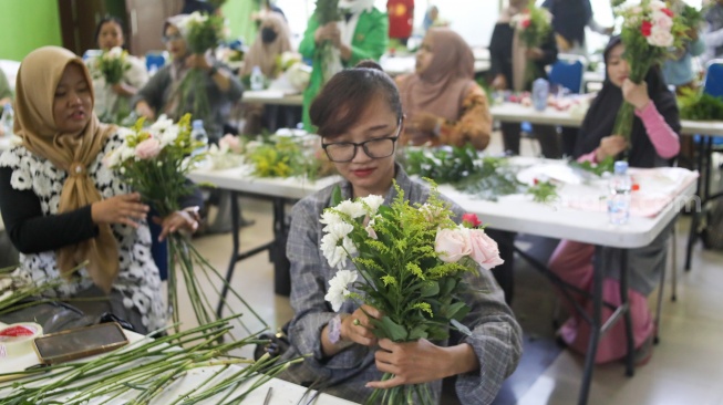 Peserta mengikuti bimbingan merangkai bunga atau hand bouquet di rangkaian Festival Hortikultura 2025 di Pasar Rawa Belong, Jakarta, Rabu (22/10/2025). [Suara.com/Alfian Winanto]
