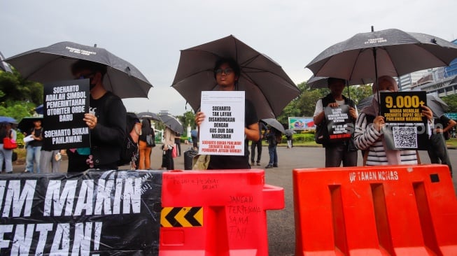 Para aktivis dari sejumlah organisasi masyarakat sipil saat mengikuti Aksi Kamisan ke-883 di depan Istana Merdeka, Jakarta, pada Kamis (23/10/2025). [Suara.com/Alfian Winanto]