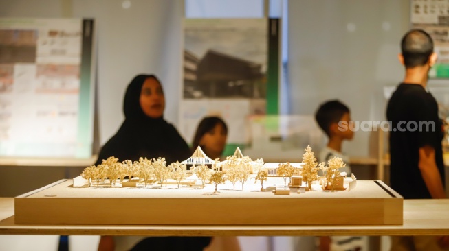 Pengunjung mengamati instalasi maket bangunan dalam Jakarta Architecture Festival 2025 di Blok M Hub, Jakarta, Kamis (23/10/2025). [Suara.com/Alfian Winanto]
