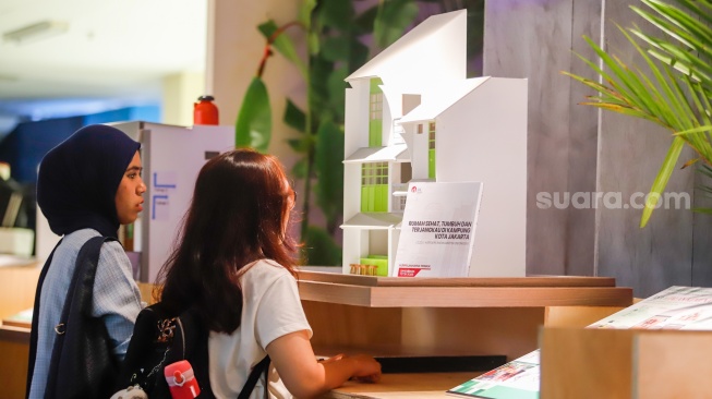 Pengunjung mengamati instalasi maket bangunan dalam Jakarta Architecture Festival 2025 di Blok M Hub, Jakarta, Kamis (23/10/2025). [Suara.com/Alfian Winanto]
