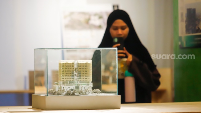 Pengunjung mengamati instalasi maket bangunan dalam Jakarta Architecture Festival 2025 di Blok M Hub, Jakarta, Kamis (23/10/2025). [Suara.com/Alfian Winanto]