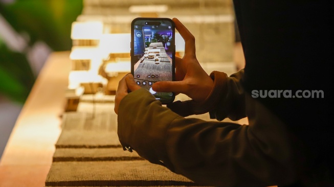 Pengunjung mengamati instalasi maket bangunan dalam Jakarta Architecture Festival 2025 di Blok M Hub, Jakarta, Kamis (23/10/2025). [Suara.com/Alfian Winanto]