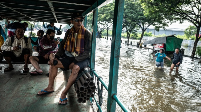 Sejumlah warga menumpang truk untuk dapat menembus banjir yang menggenangi jalur utama pantura Semarang-Surabaya di Jalan Kaligawe Raya, Semarang, Jawa Tengah, Jumat (24/10/2025). [ANTARA FOTO/Aprillio Akbar/YU]