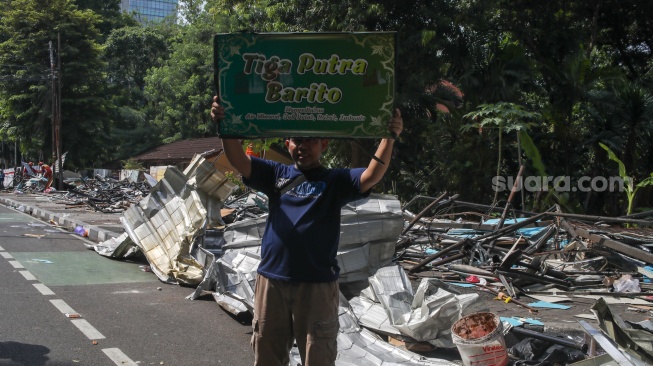 Petugas membongkar kios menggunakan eskavator di Pasar Hewan Barito, Jakarta, Senin (27/10/2025). [Suara.com/Alfian Winanto]